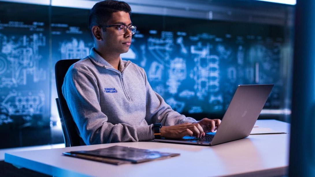 A student works on an assignment at his automotive co-op job.